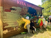 Kunterbunt aus Kinderhand: Kinder der Kita Naturzauber bemalen die Waldhütte